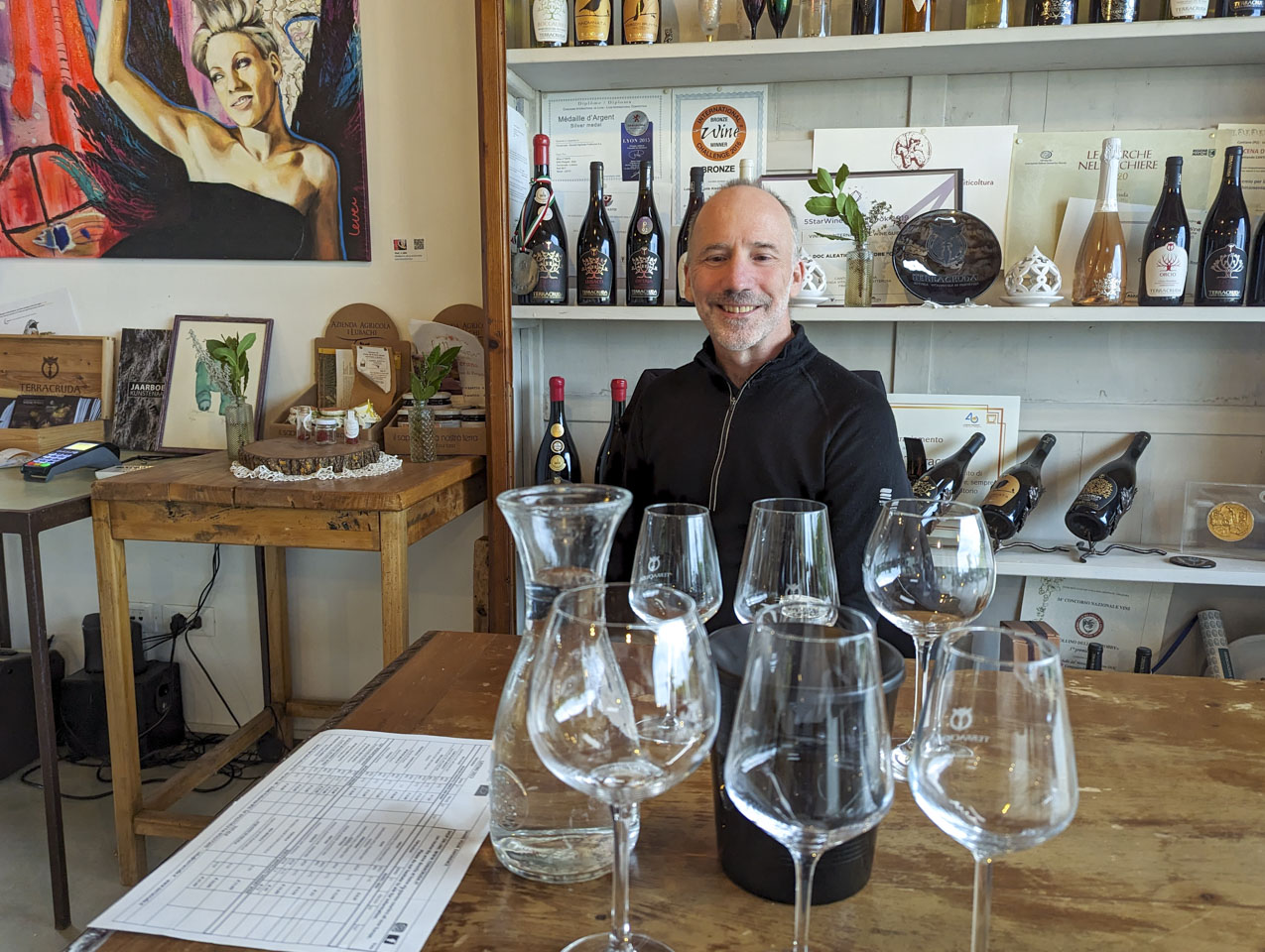Paul in the tasting area of Terracruda, with wine glasses in front of him.