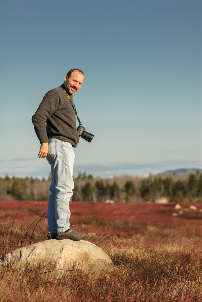 Paul standing on a rock with blueberry field behind him