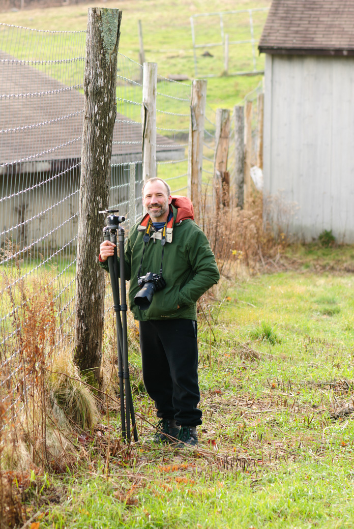 Paul standing next to a tall deer fences