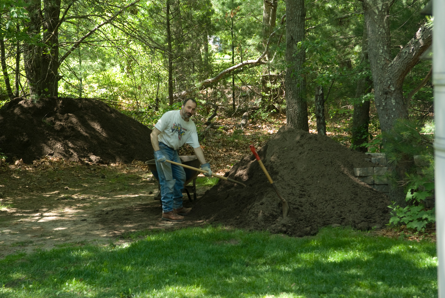 Paul shoveling dirt into wheelbarrow