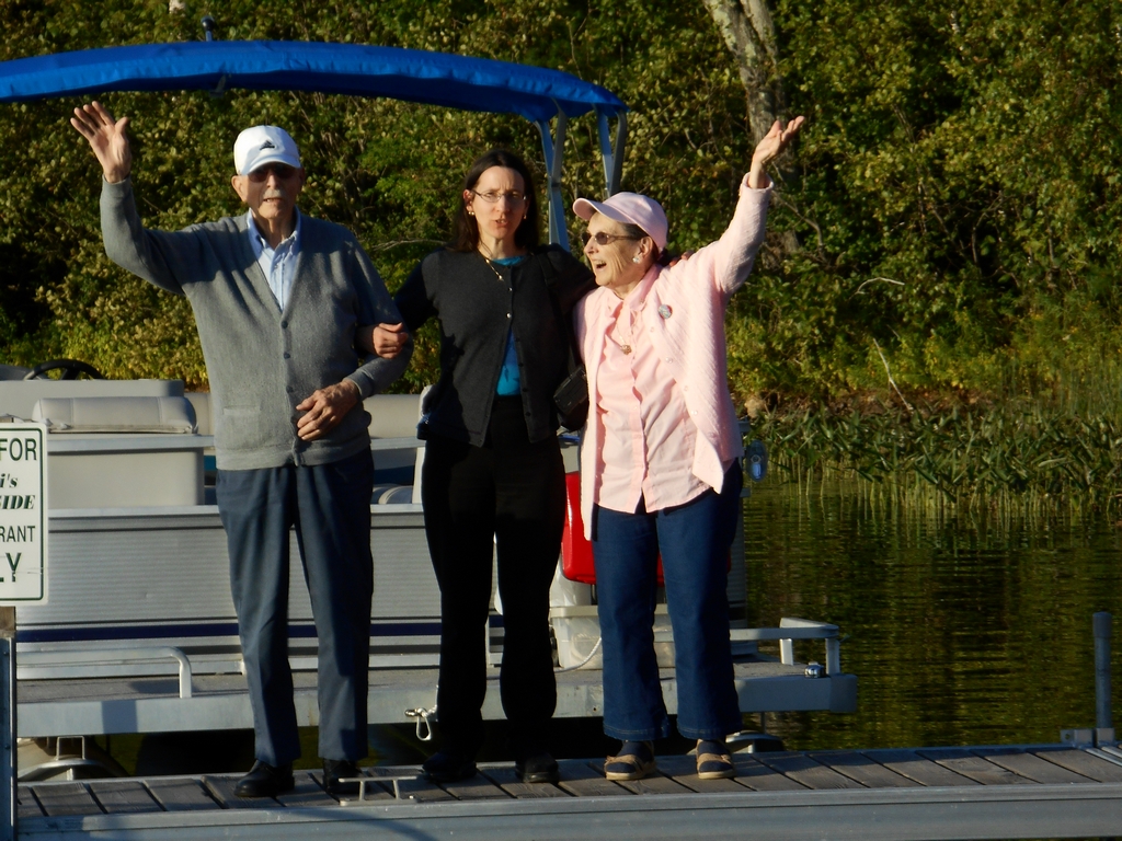 Gerry, Anne, and Mom standing together on the dock at Cyndi's Dockside with a pontoon boat behind them