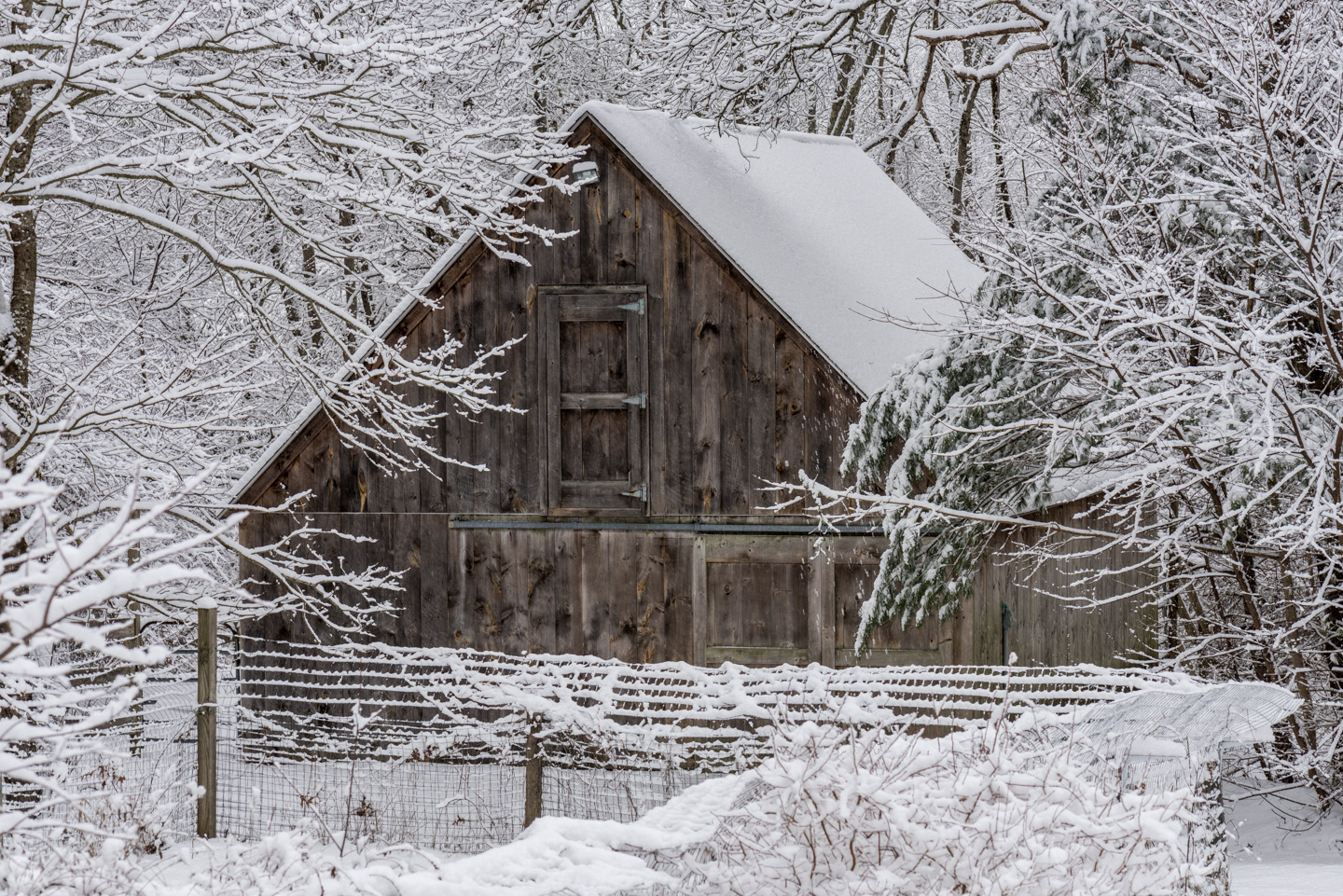 The barn with some snow and the garden fence
