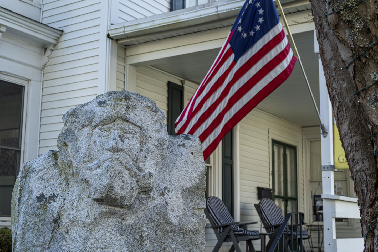 sculpture with a man’s face with the inn’s flag behind it