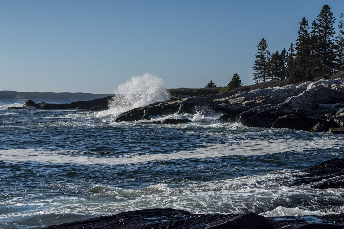 A wave crashing against rocks