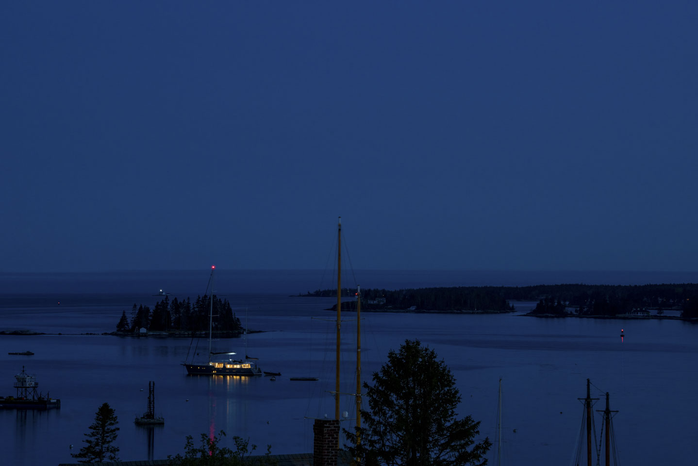 Ship on the water with its lights on, plus some other navigation lights