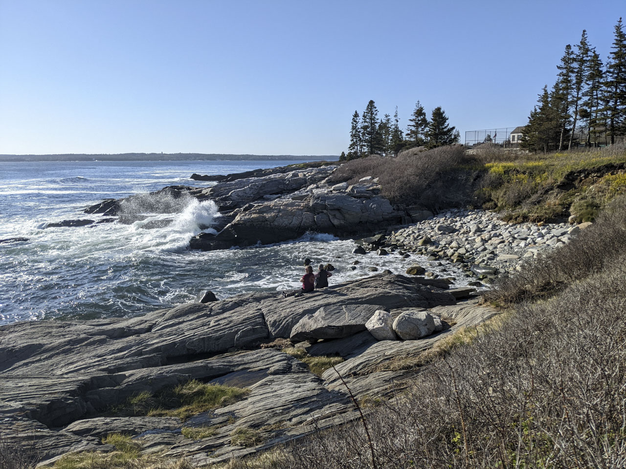 a couple people on the rocks near the ocean. Taken with a Google Pixel.