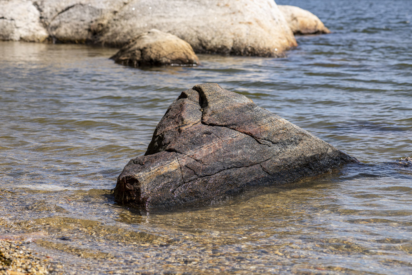 Large red rock in the water