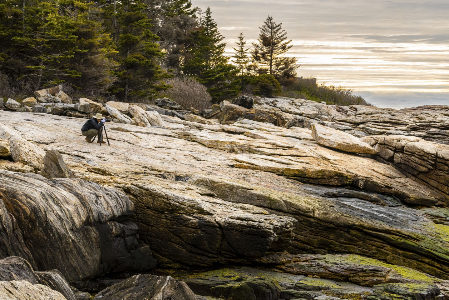 Anne taking a picture while on rocks at Ocean Point