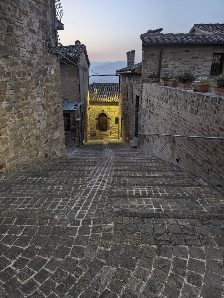 Looking down a street in Nidastore towards a building that has a light shining on it