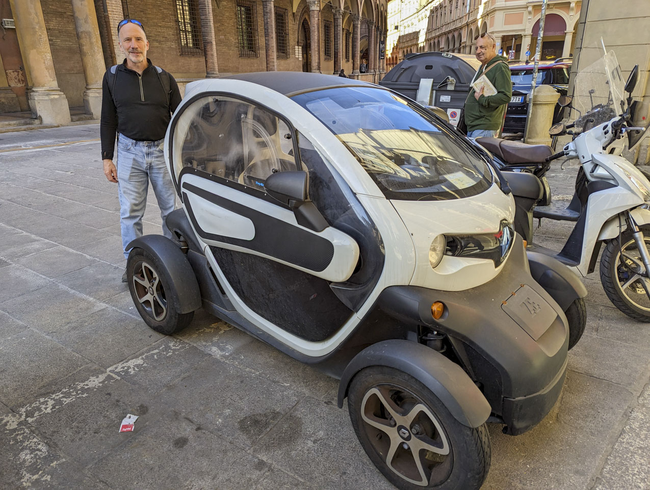 Paul standing next to a small Renault Twizy in Bologna.