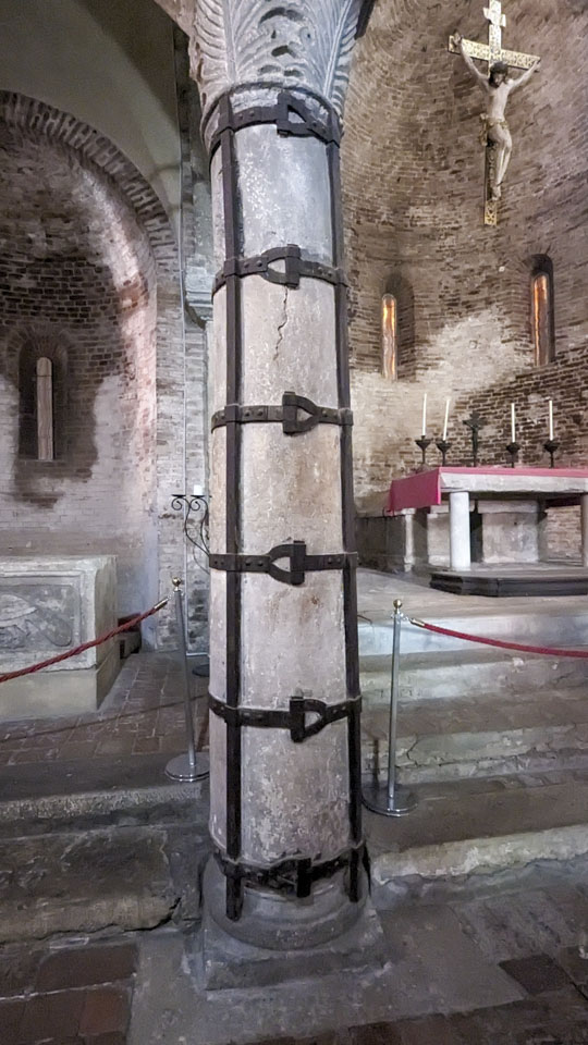 A closer view of one of the columns, which has large iron bars and straps around it for support.