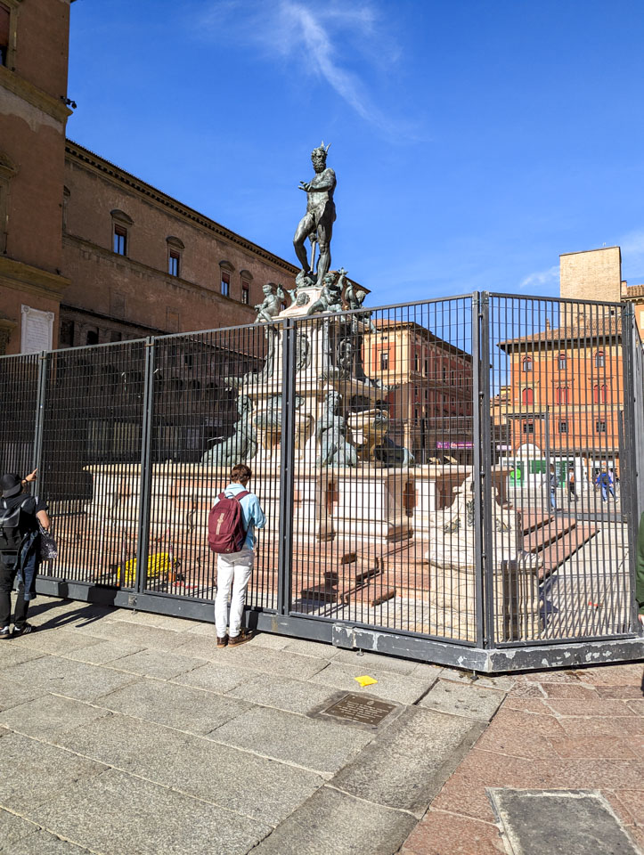 The statue of Neptune with fencing surrounding it.
