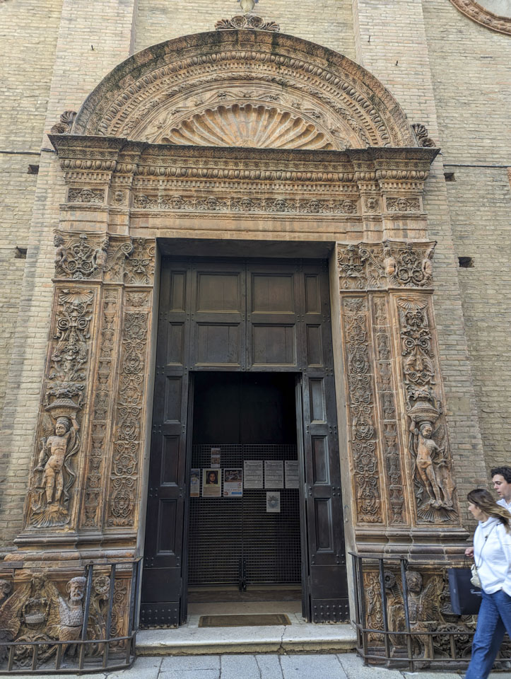 A large doorway with richly embellished decorations around it, including small figures and faces.