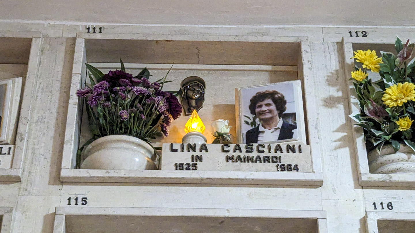 The front of Lina's tomb, with purple fresh flowers and a photo of the deceased.