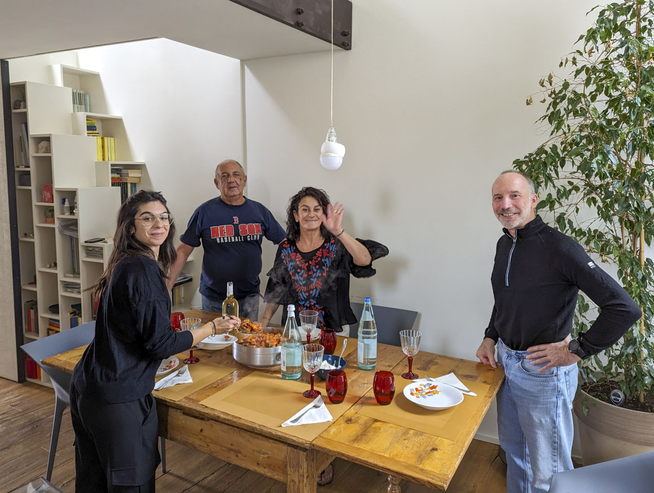 Flo, Francesco, Doni, and Paul stand around a wood table