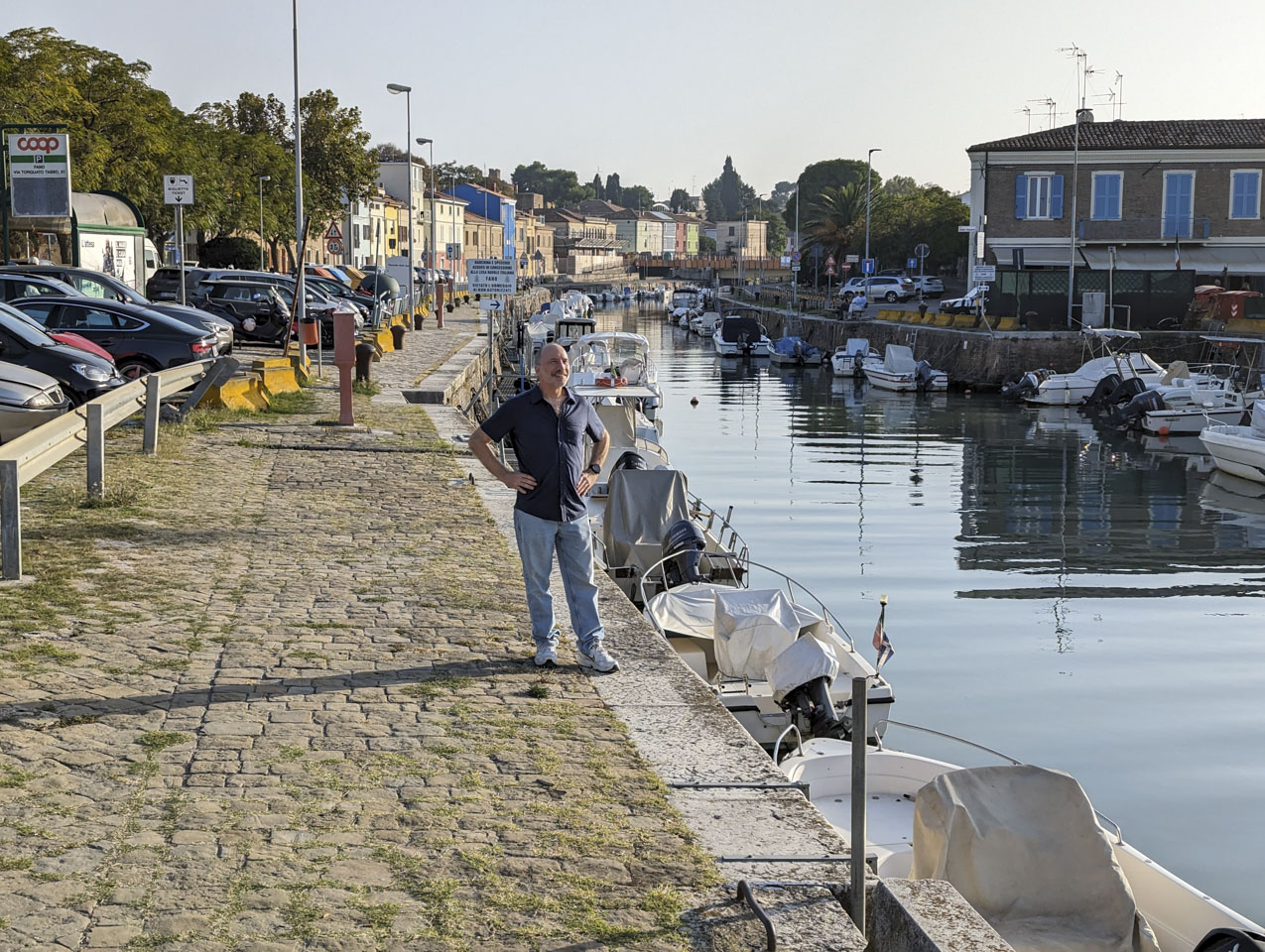 Paul standing next to the canal, wearing a short-sleeved shirt and jeans
