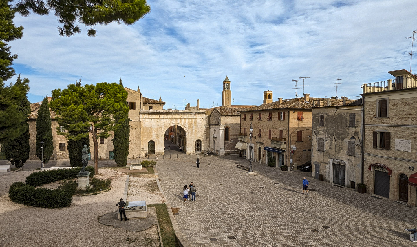 View of the Old Town Plaza from a slightly elevated position. Anne can be seen looking at one of the dioramas. The statue of Augustus is on the left, and the Arch of Augustus is in the center distance. Old buildings are on the right.