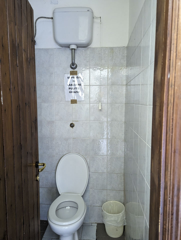 one of the bathroom stalls with a pull cord water tank