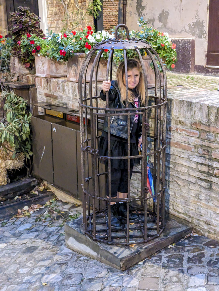 Giulia standing inside an iron cage.
