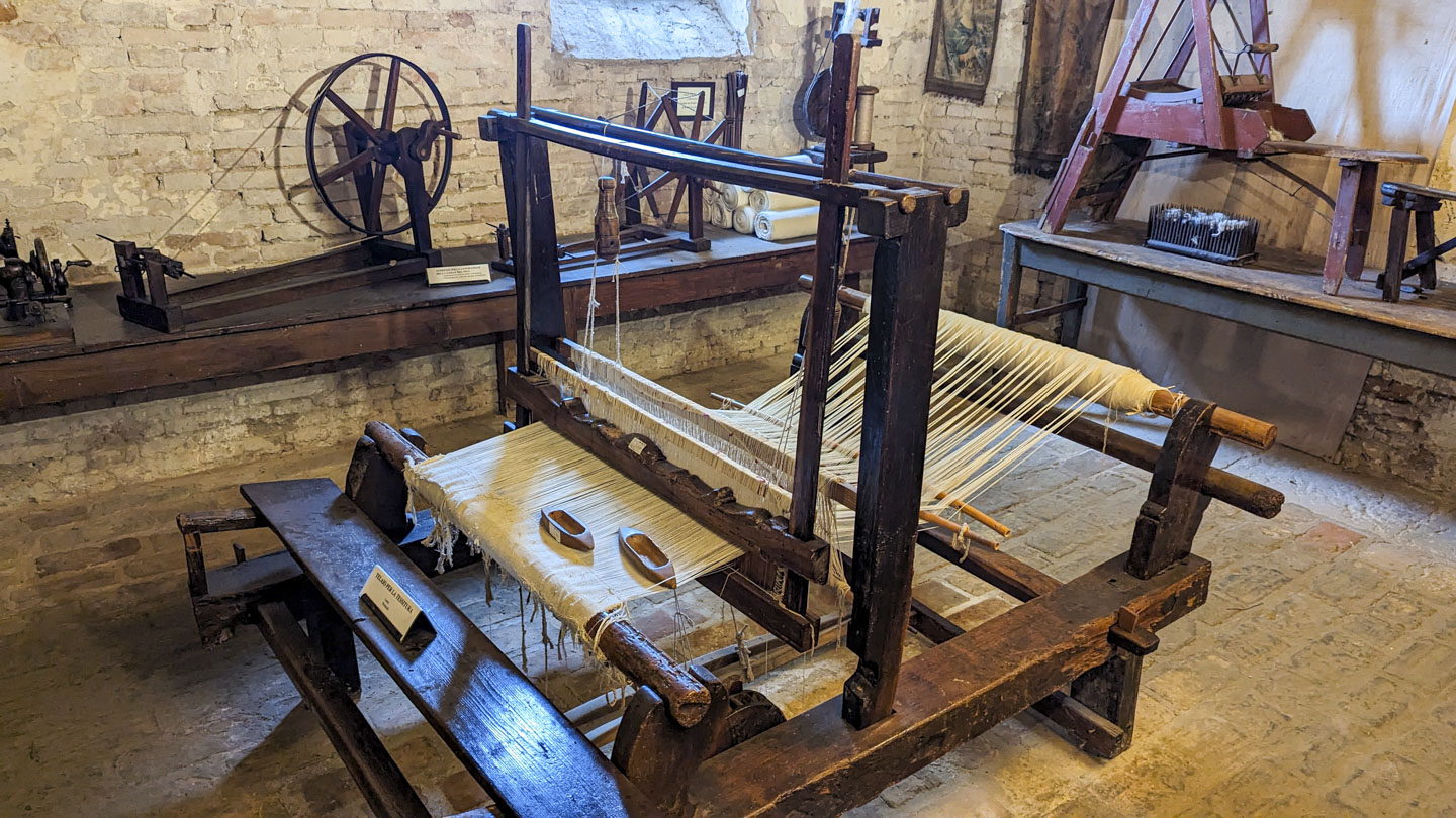 A loom with some sample work on it.