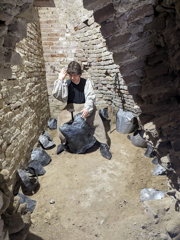 A museum display of a man working inside La Rocca in Mondavio