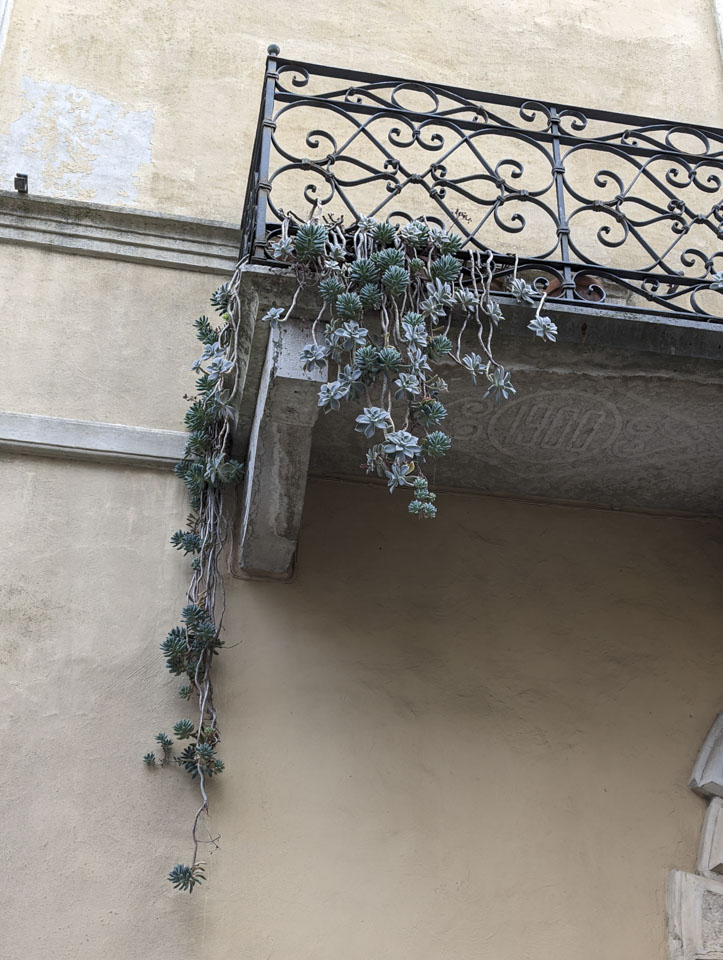 The bottom of a small balcony with the number 1900 engraved in the stone