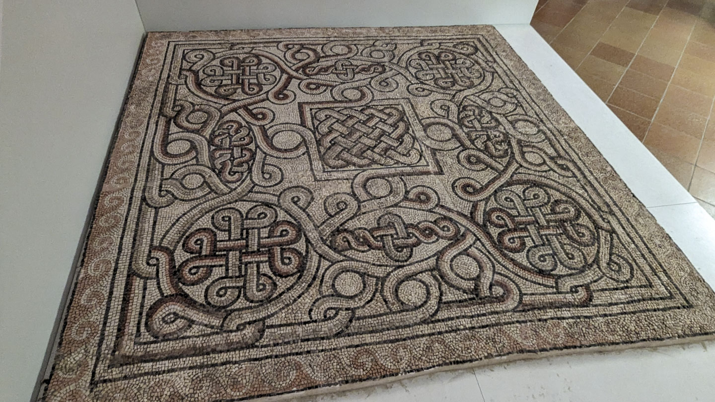 A mosaic of tan colors with geometric designs on it.