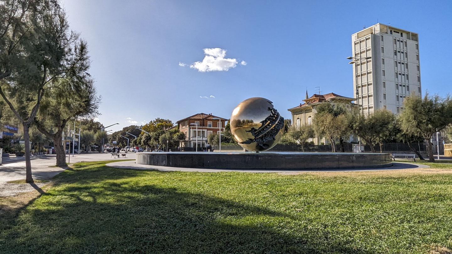 Looking back at The Great Sphere with the buildings of the city behind it.