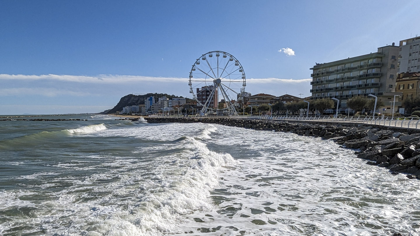 Water is on the left and shore is on the right. The Ferris wheel can be seen in the distance.