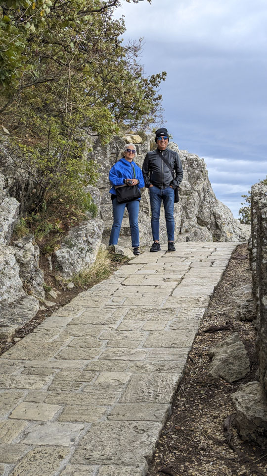 Alizia and Roberto stand on the edge of a stone path, with looks to have been carved out of the surrounding stone.