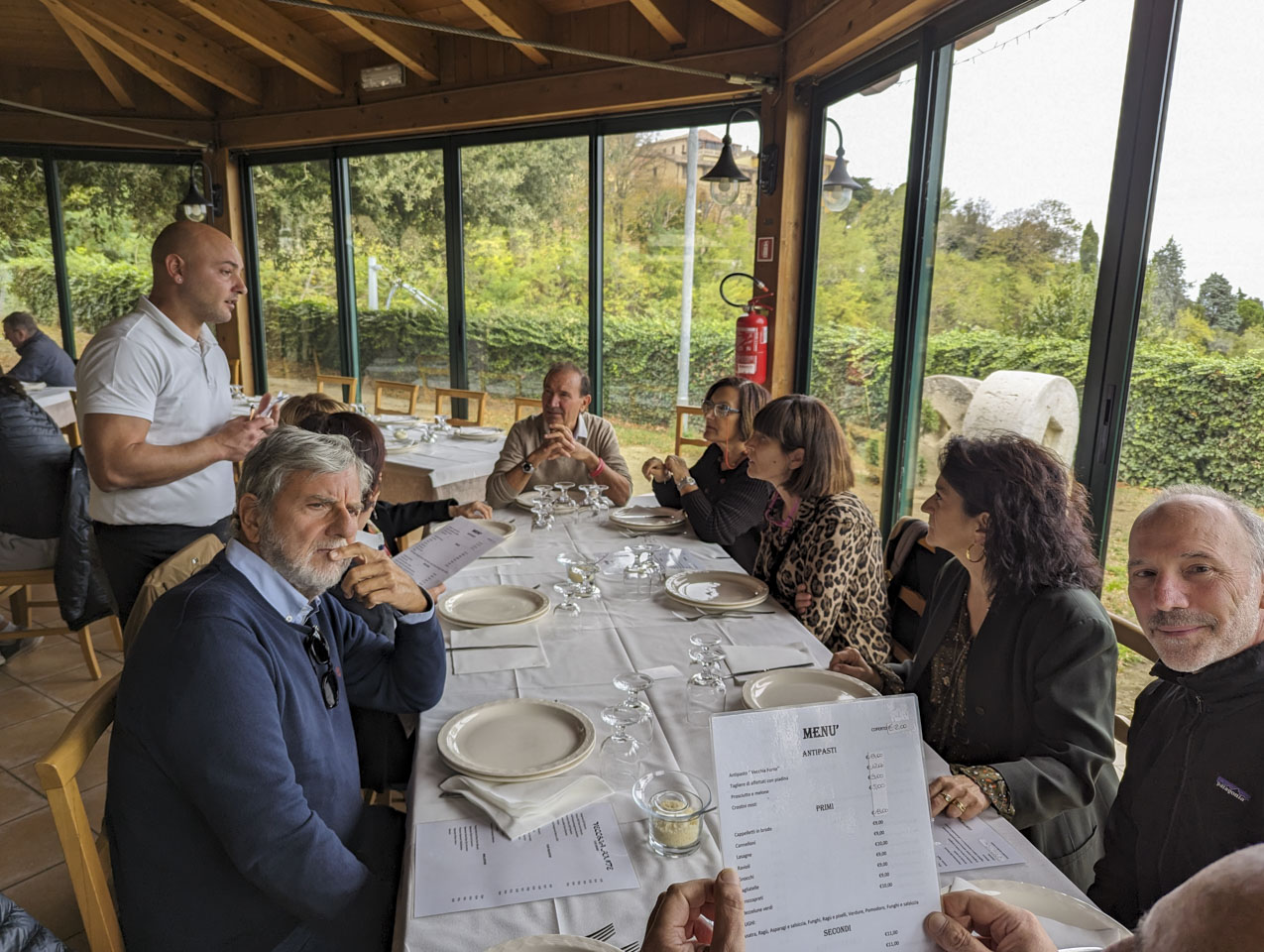 A large table at a restaurant with large windows through which greenery can be seen.