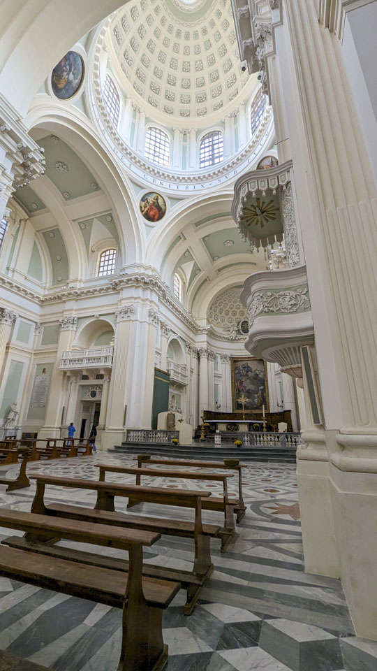 A long view of the front of the church. There is a small pulpit on the column immediately in front of you. The altar is in the distance, and to the left of the altar is a balcony where the Duchess would sit.