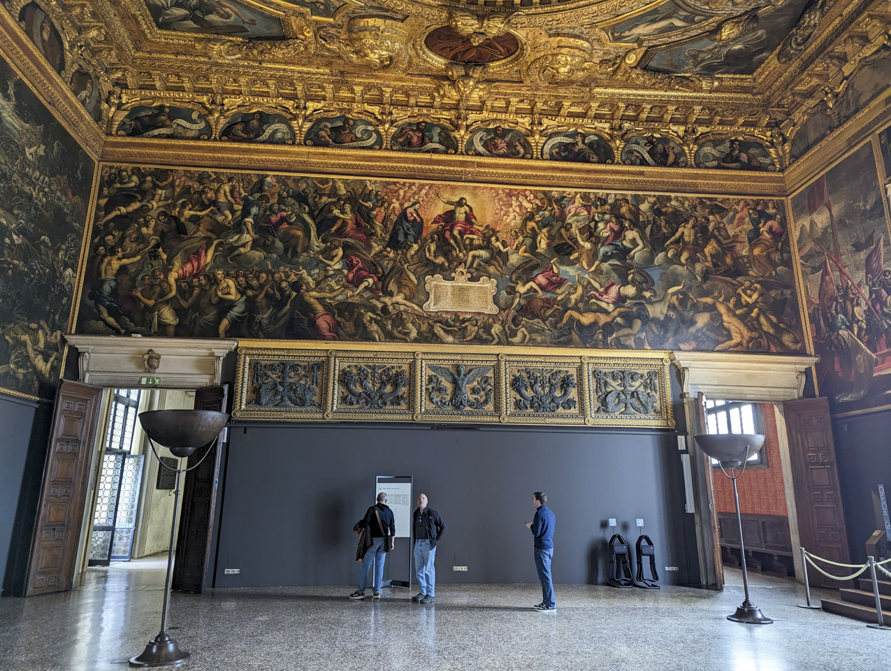A view of the Great Council room of the Doge Palace. The walls and ceilings are covered with paintings and gold trim.
