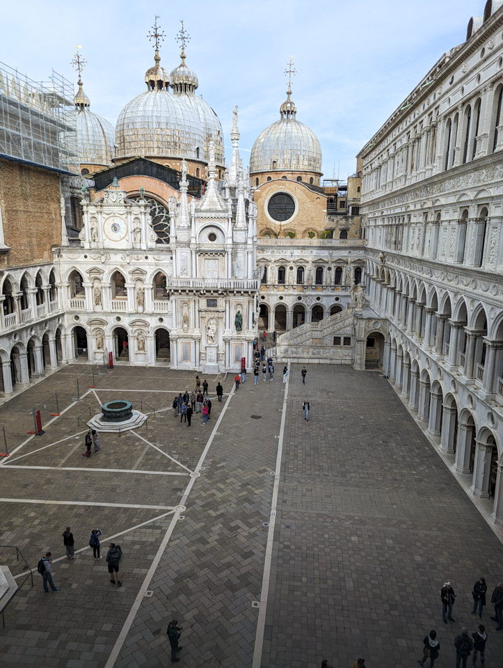 A view of the palace courtyard from an upper story window, looking towards the basilica. Four domes can be seen.