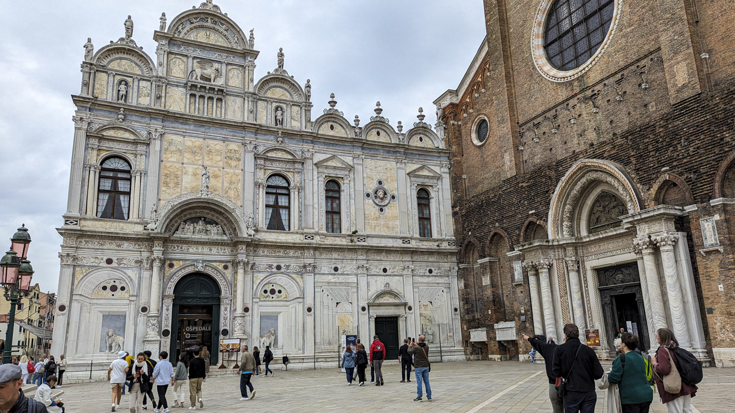 The ornate front of the Venice hospital, with a carved lion on each side of the entrance, a winged lion
