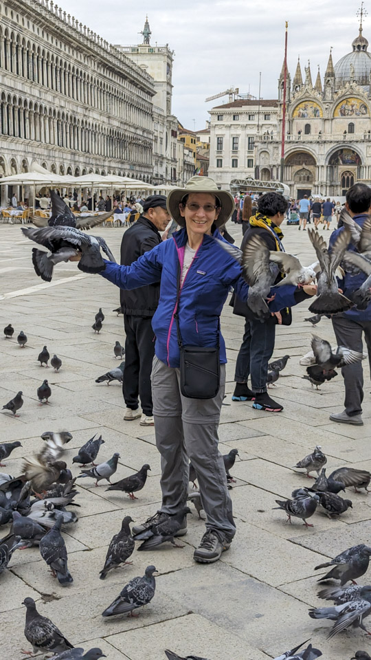Photo of Anne is St Mark's Square with pigeons on her arms.