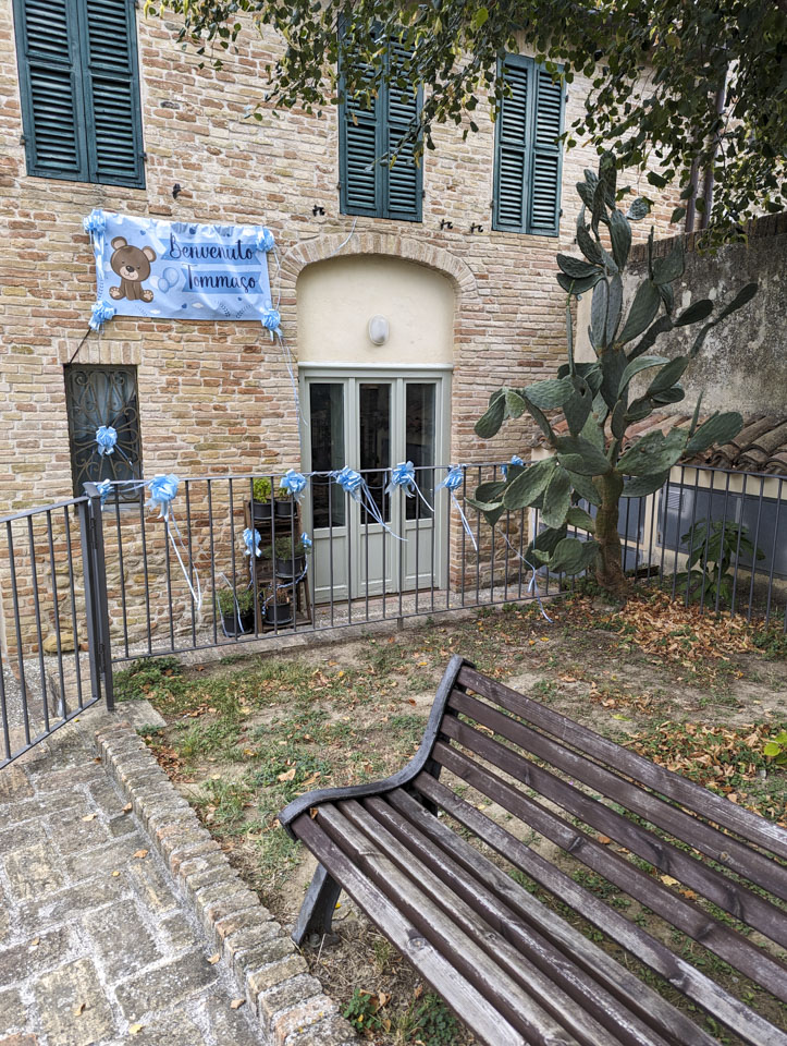 A house with a large blue sign that says Benvenuto Tommaso