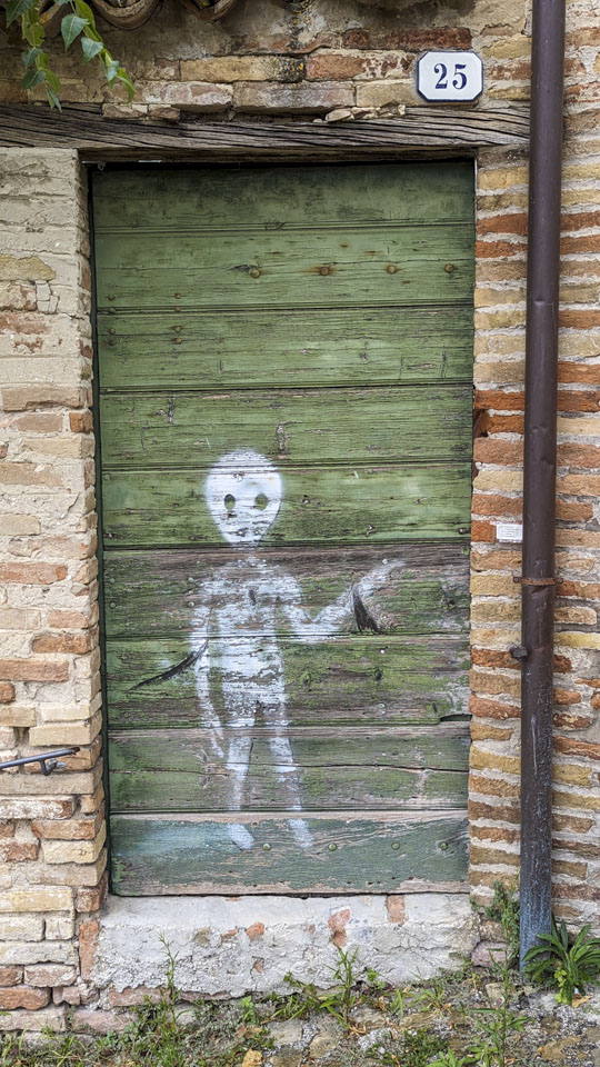 alien painted in white on a green door