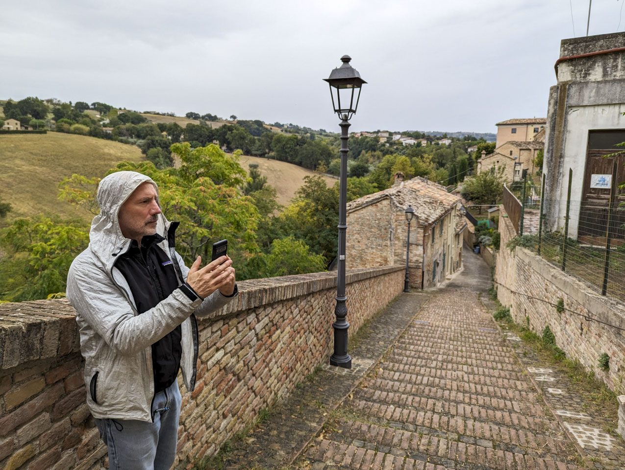 Paul with his cell phone in hand, on a steep brick roadway