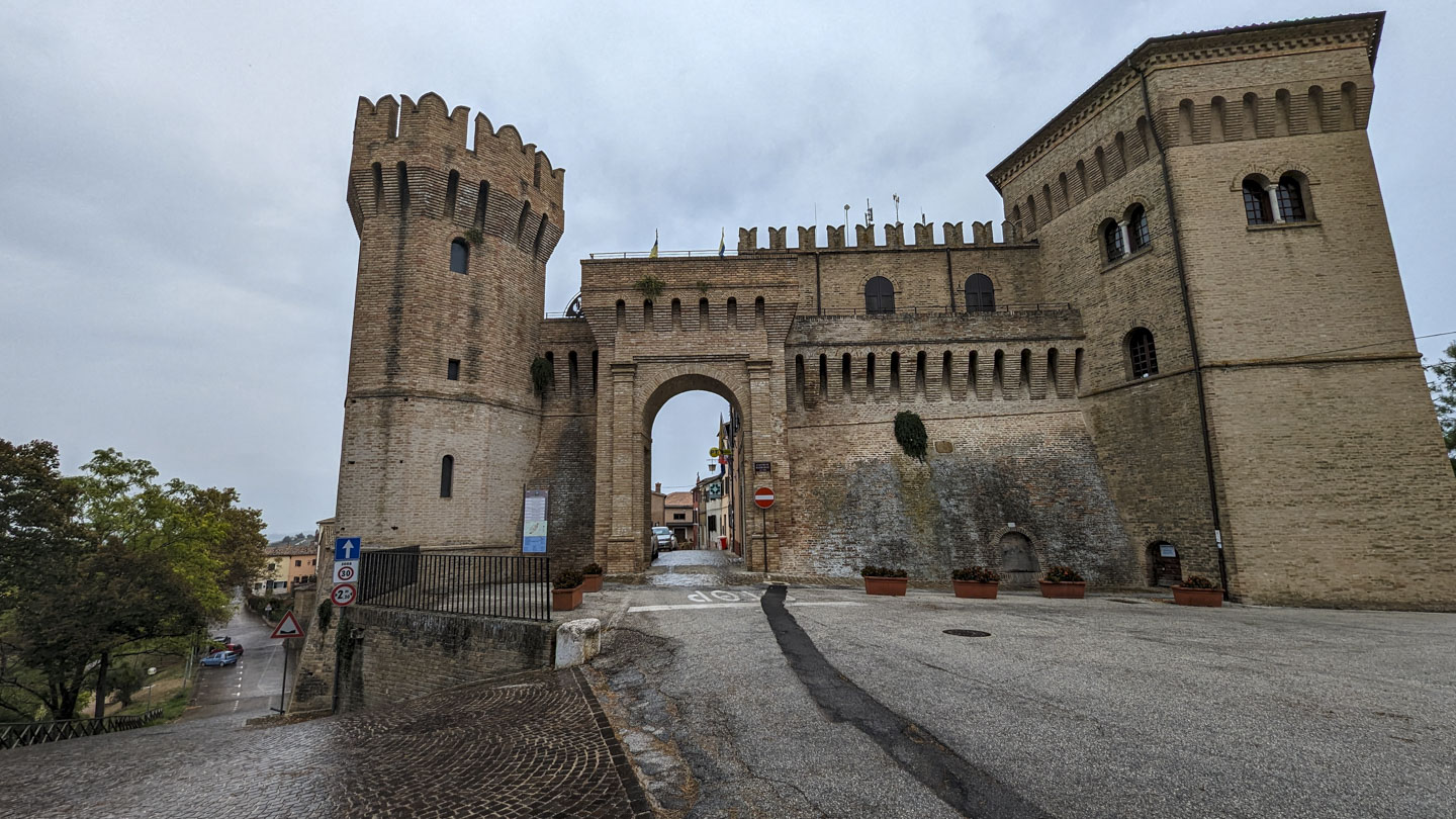 Exit from Barbara Centro, with a high arched opening in the stone wall and towers on each side