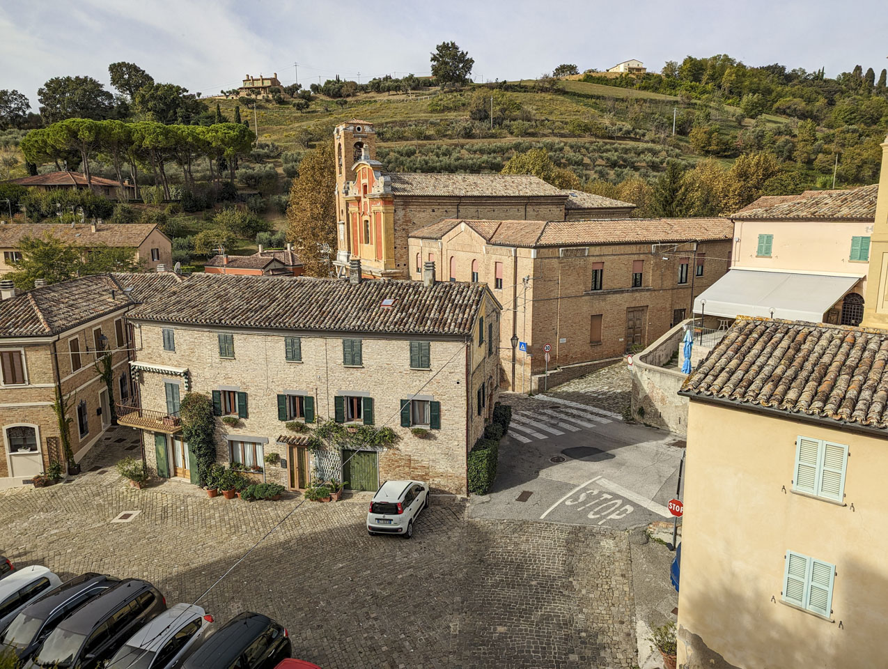 Looking down at some stone buildings and to the hill that is past them