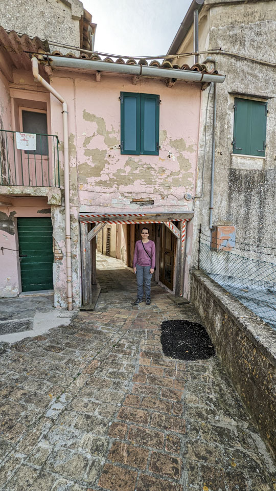 Anne standing under a covered section of the road; the top of the opening is not much higher than her head.