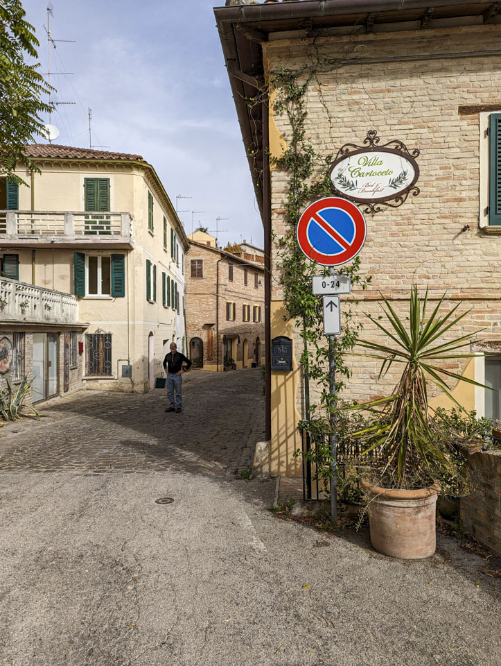 Paul on the road into Cartoceto, with a sign for a local B&B