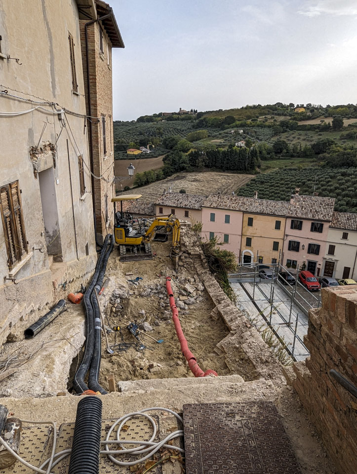 Looking back the other way at that machine, we can see some pipes that must be under the stairs. In the distance are olive groves.