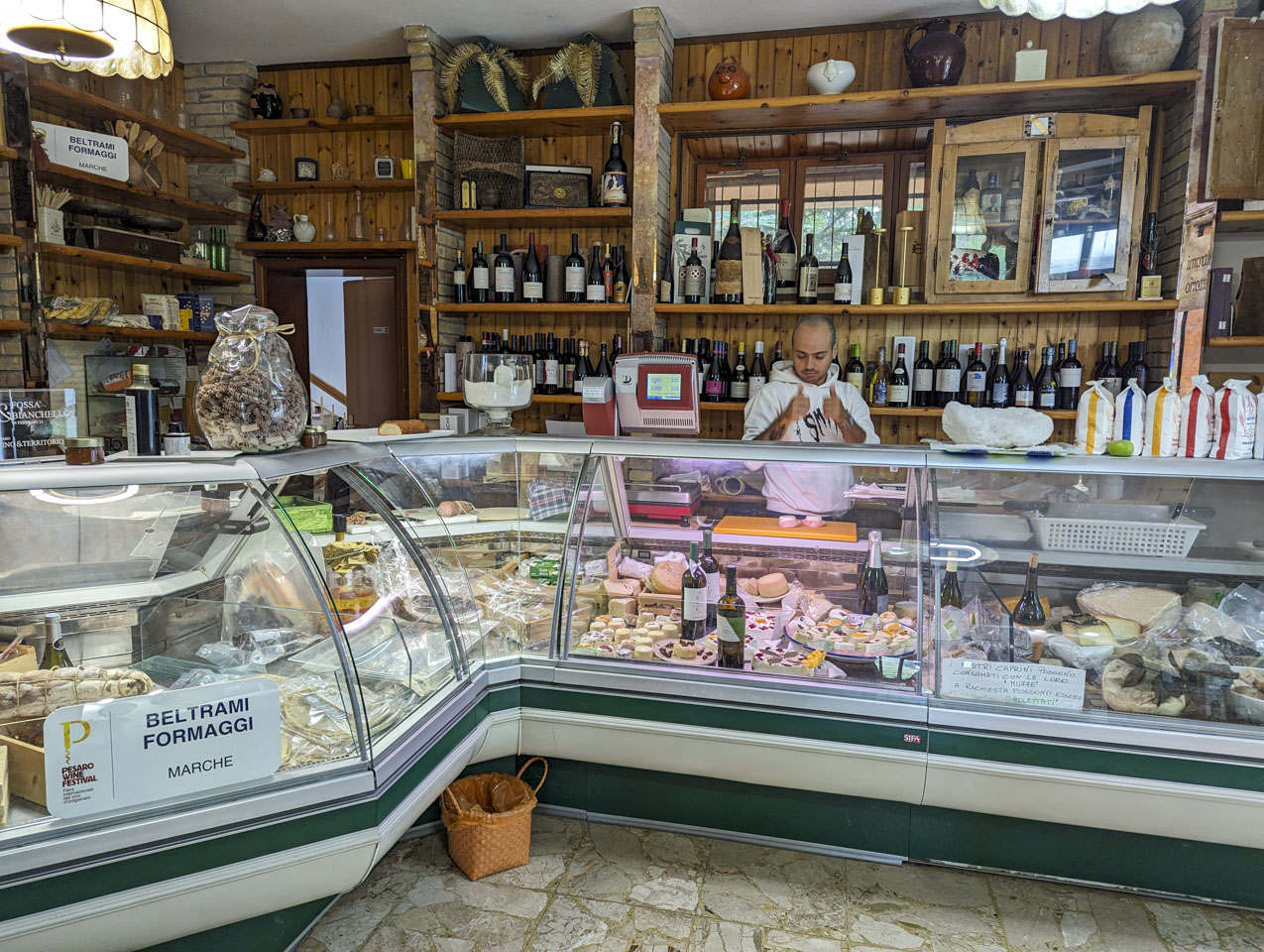 Deli refrigerator counter with many types of cheese and other food.