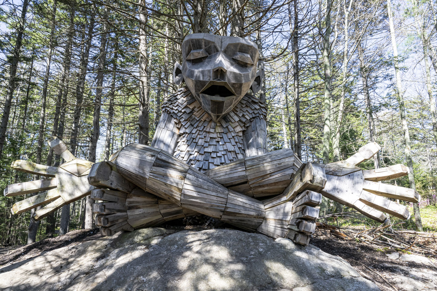 A plain-faced wooden troll sits and meditates.