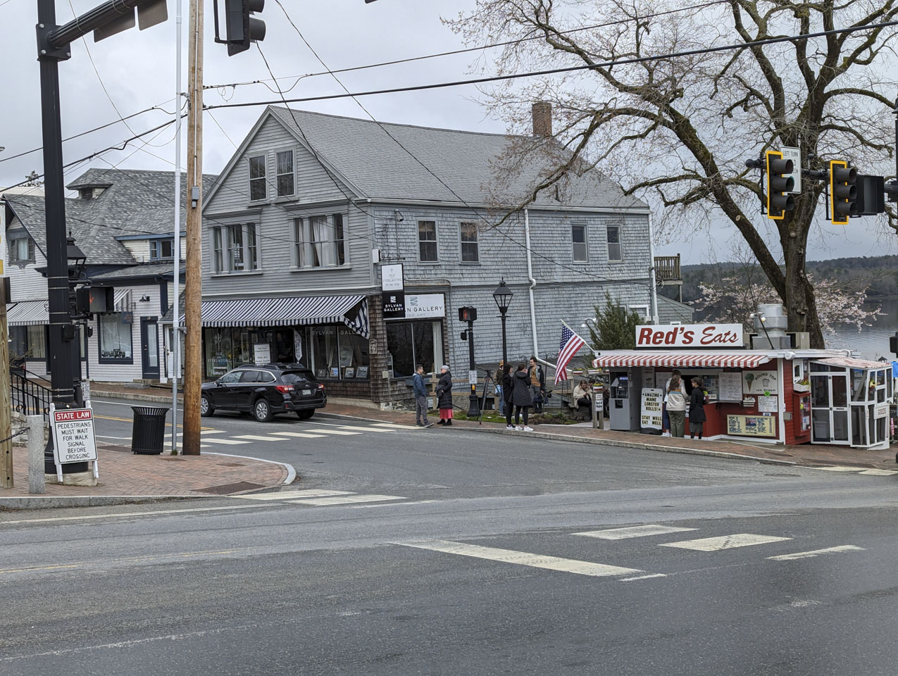 A grey building has a sign that says sylvan Gallery. Near it is the restaurant stand Red's Eats.