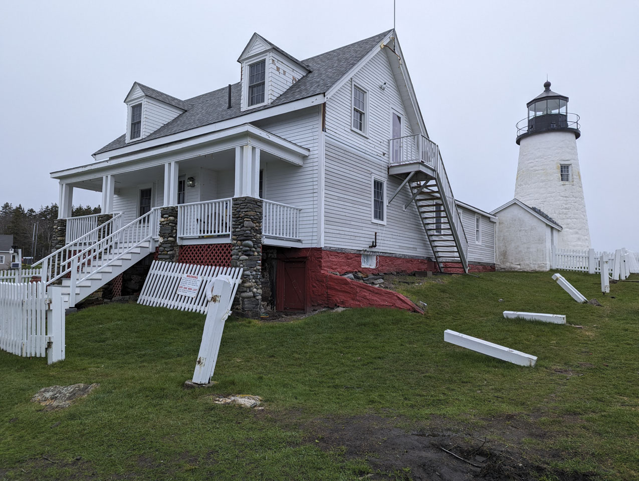 Pemaquid Light House has a little damage to the side of the building, but has lost a good portion of the picket fence.