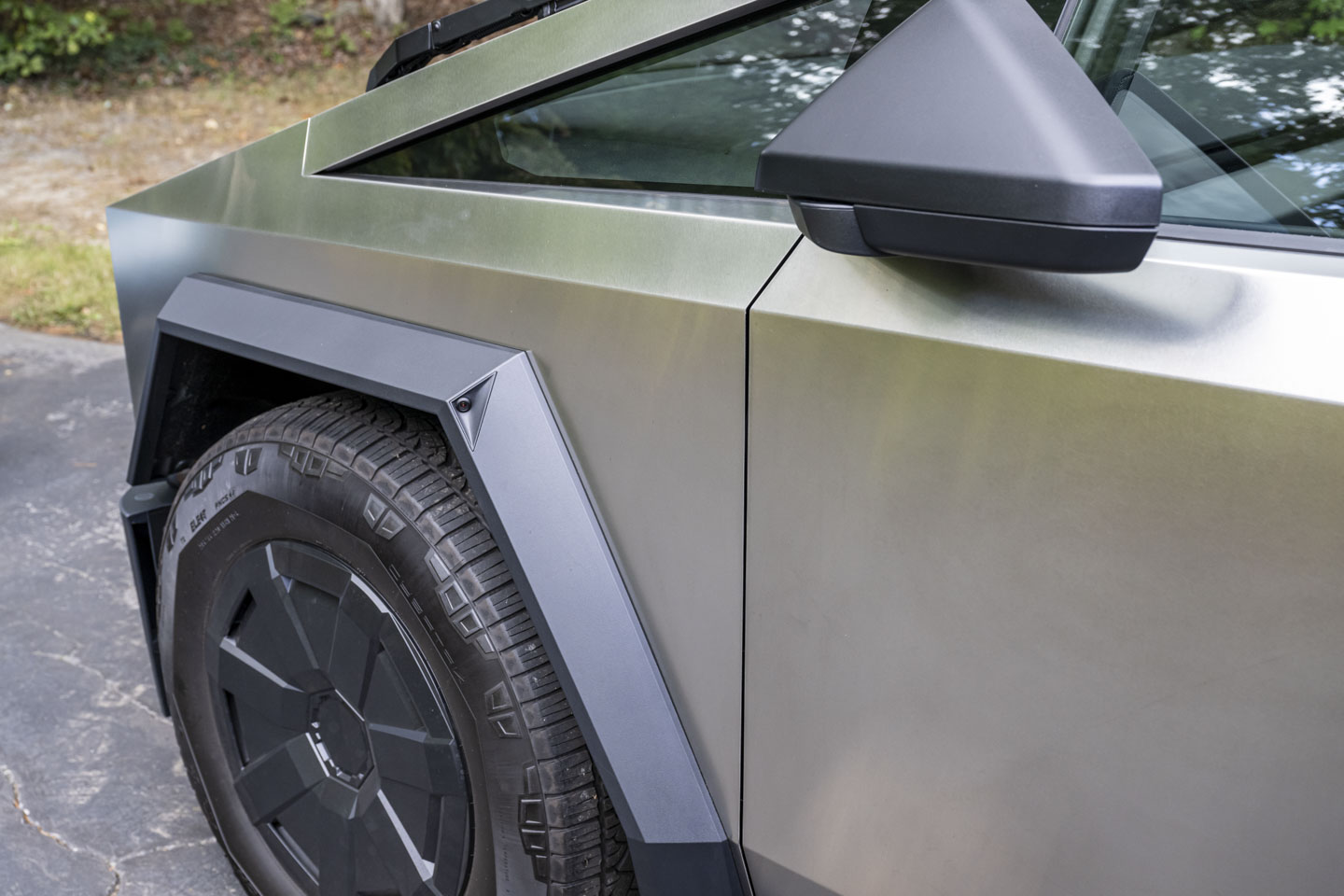 A view of the Cybertruck tire.  Above it in the frame is a red spot that is a camera.