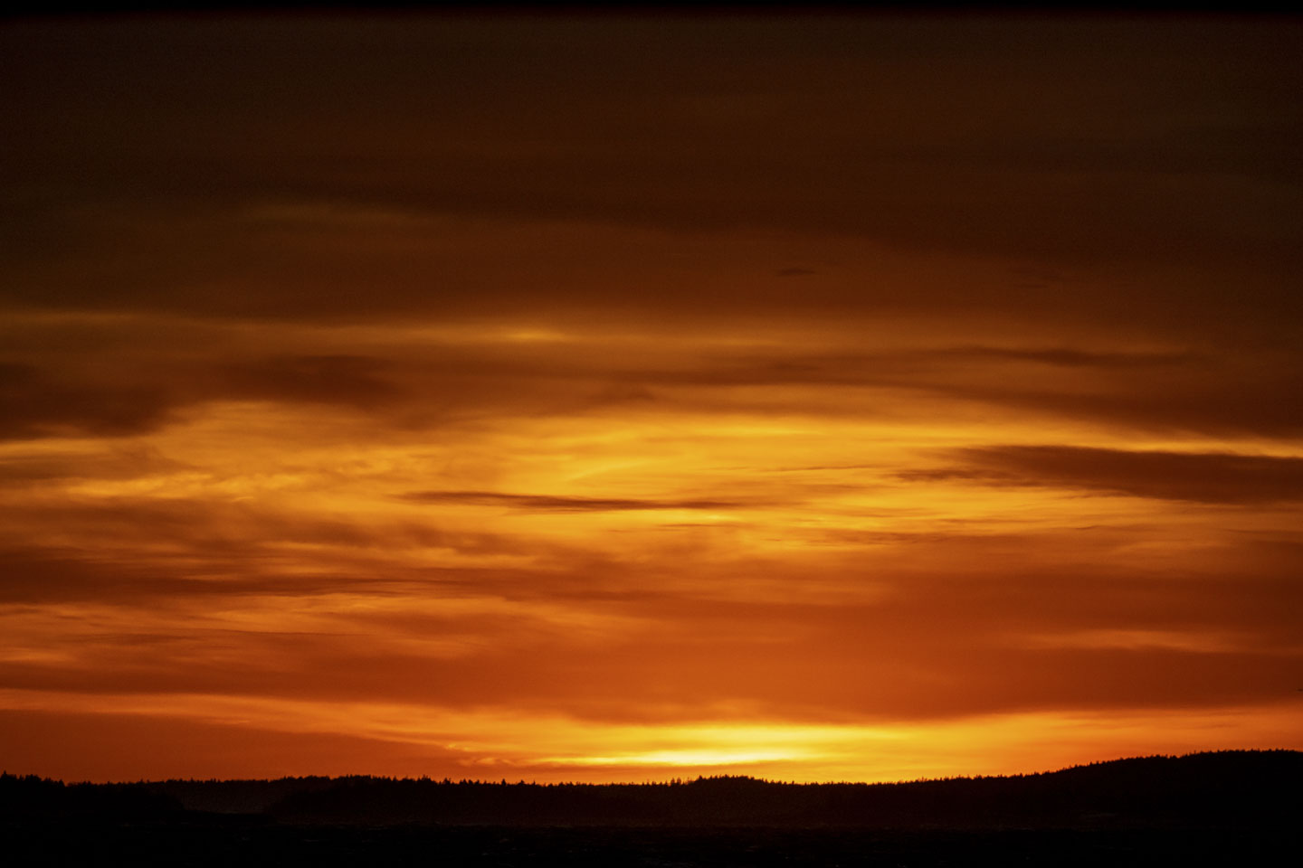 A bright orange and yellow sky fades off into darkness.